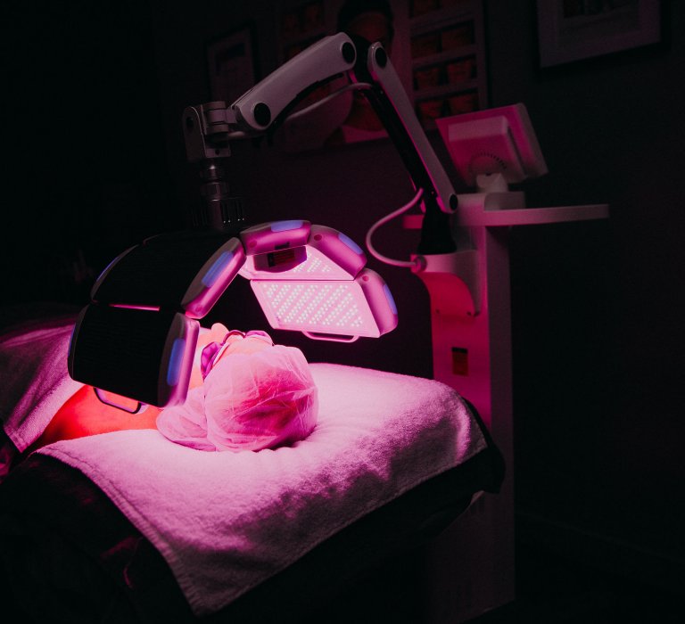 A person undergoing LED therapy - pink light