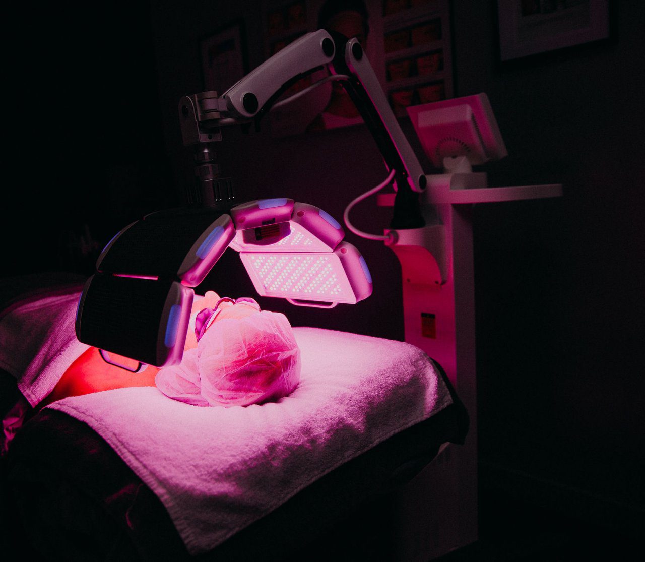 Person laying on her back undergoing LED therapy