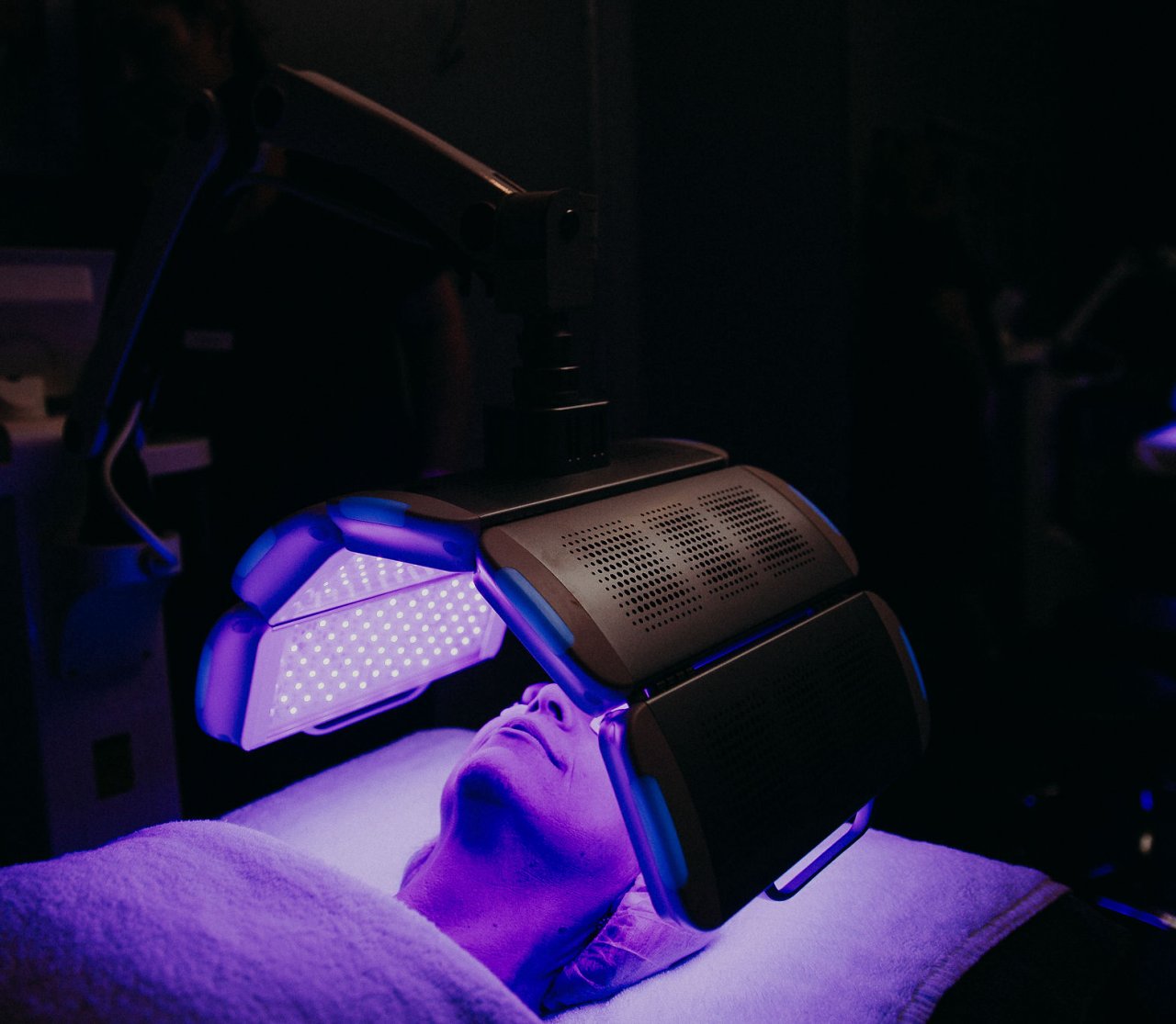 Person laying on her back undergoing LED therapy