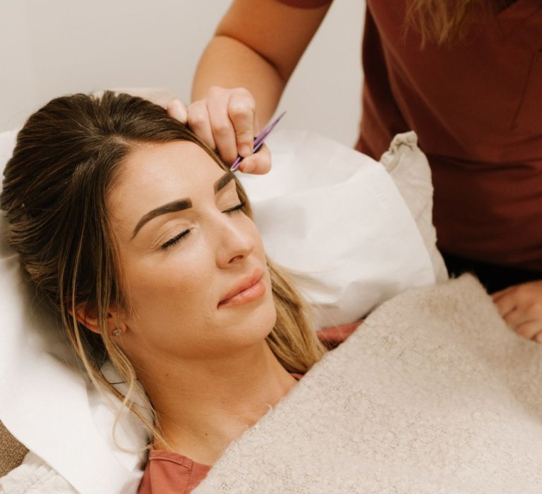 A lady getting her eyebrows done at New You