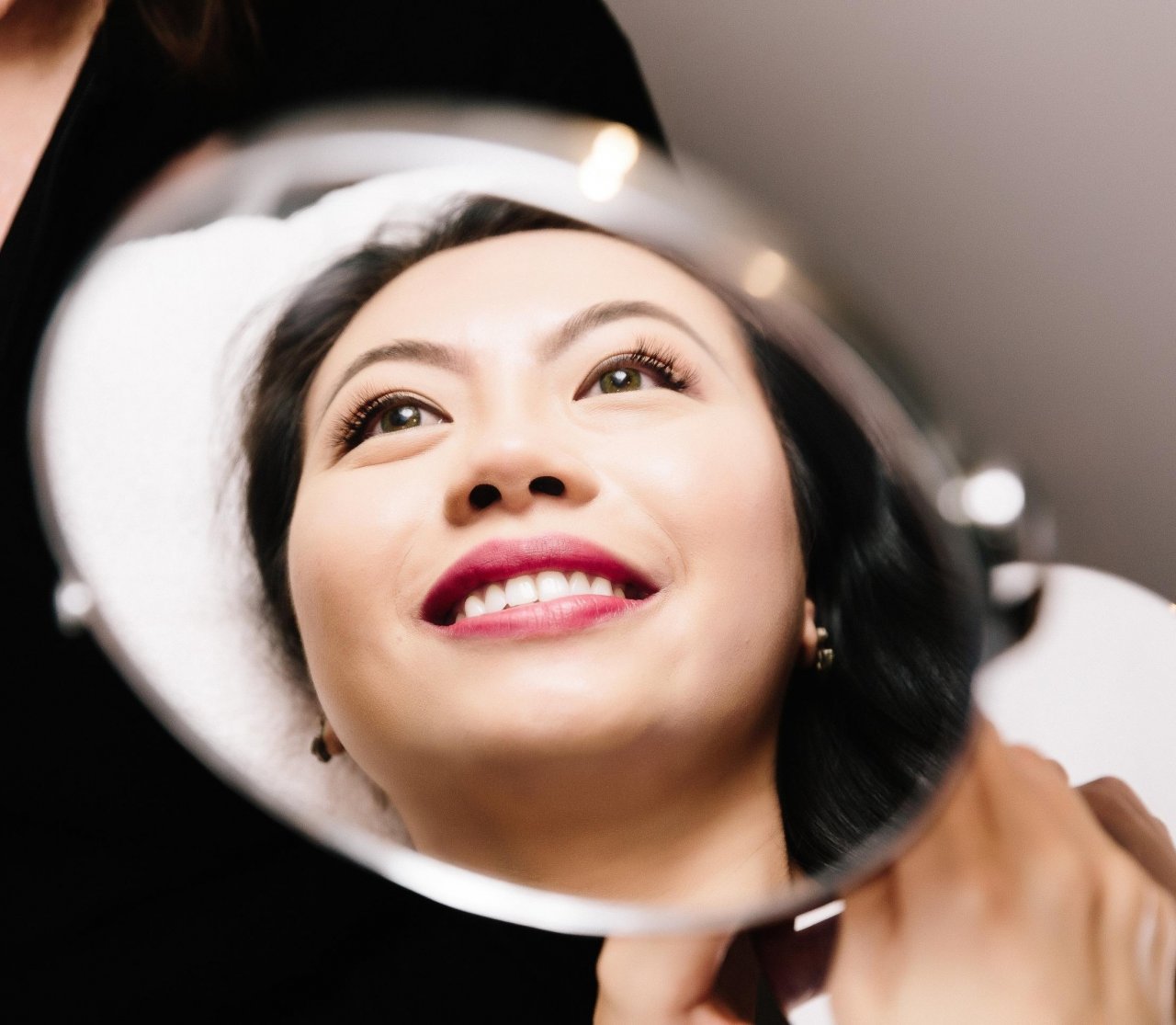 Woman smiling looking at herself in a mirror