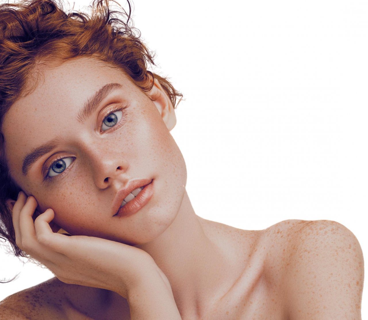 A woman with freckles resting on her hand