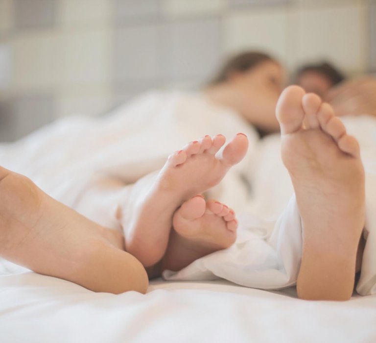 Two people lying in bed